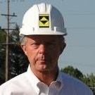 Leonard J. Theisen, the founder of Site Development, Inc., wearing a white button up shirt and a Site Development, Inc. hardhat.